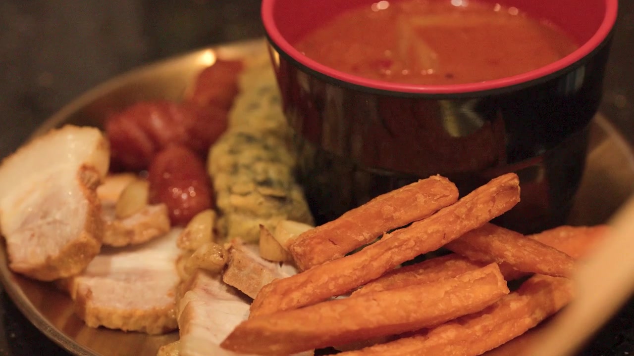 Nærbilde av koreansk kimchi-suppe, svinebuk og tempura servert i en restaurant