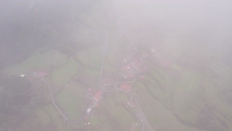 Top-down-shot-of-Portugal-countryside-at-Sobrada-village-with-low-clouds,-aerial