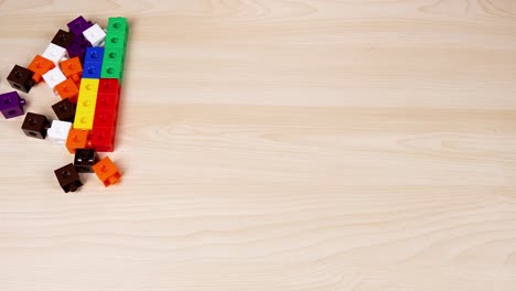 manos organizando cubos coloridos en una superficie de madera