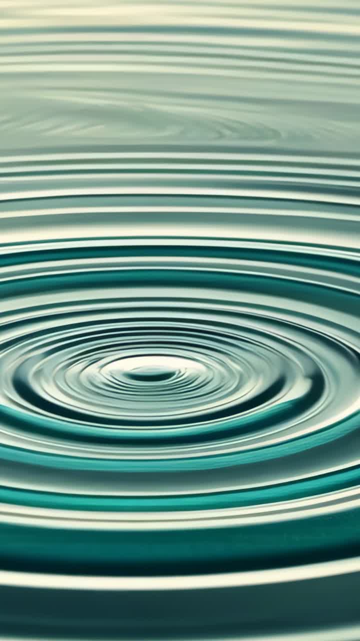 Vertical video: Impacting droplet creating ripples in green water close-up, showing wave decay