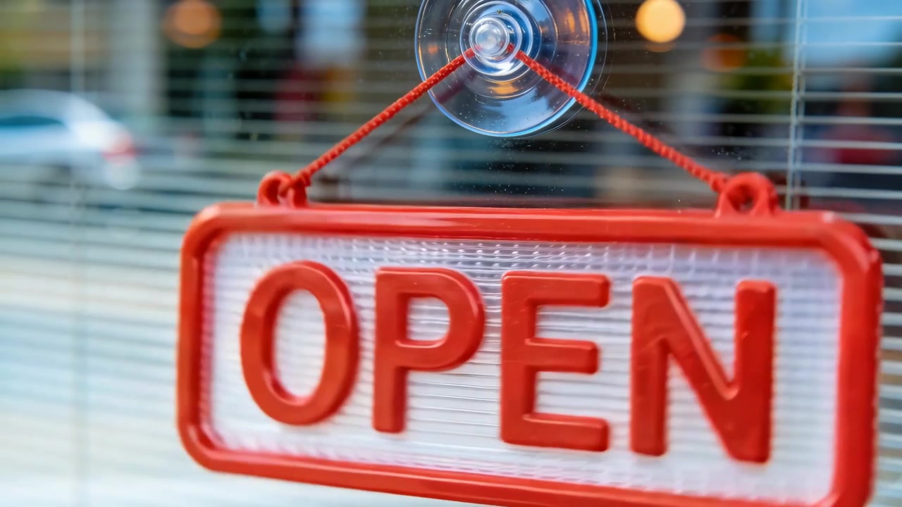 Schwingendes rotes „OPEN“-Schild, das sich nach dem Kippen im Schaufenster dreht und sich nahe der Schnur horizontal ausrichtet.