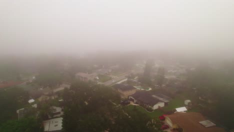 aerial flyover through foggy and misty neighborhood in city of ocoee, florida with no vehicles driving and nobody outside