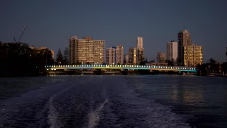 city skyline and water wake at sunset