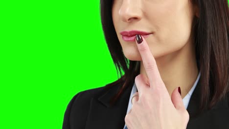 mujer de negocios poniendo el dedo en sus labios