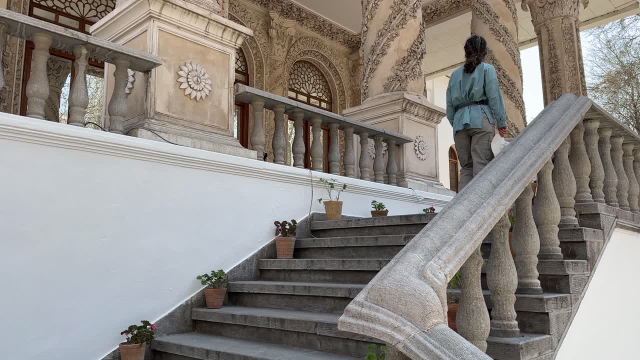 Woman walking upstairs of the Whitehouse Tehran palace Iran landmark Architectural urban landscape city summer attraction Scenic view travel Middle East People entertainment happy outdoor background