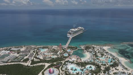 aerial flyover of bahamas islet waterpark toward caribbean cruise ship