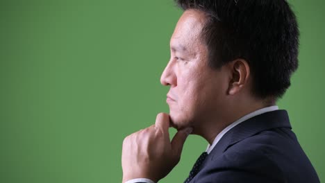 熟成した日本人のビジネスマン 緑の背景