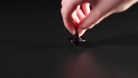 hand spinning a top on a surface