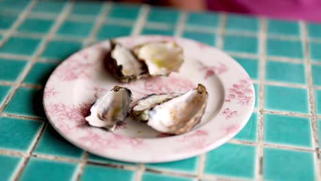 oysters being removed from a plate one by one