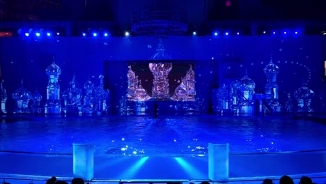 a stunning night show in tokyo with vibrant blue lights and water reflections on stage