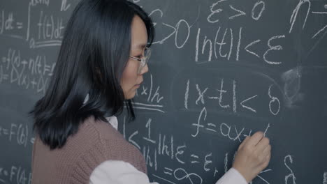 woman writing math equations on a blackboard