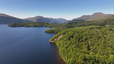 flying along the side of loch lomond shore to lift up and reveal ben lomond and mountains