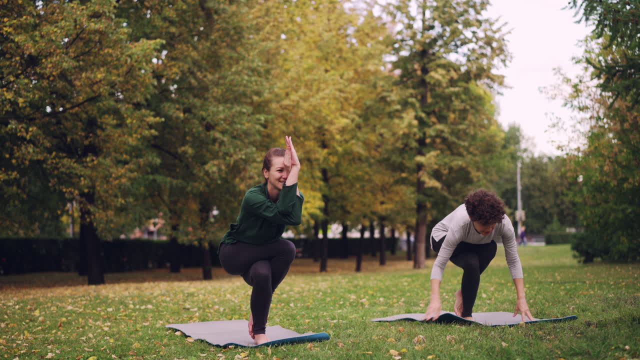 Two Women Practicing Yoga in an Autumn Park