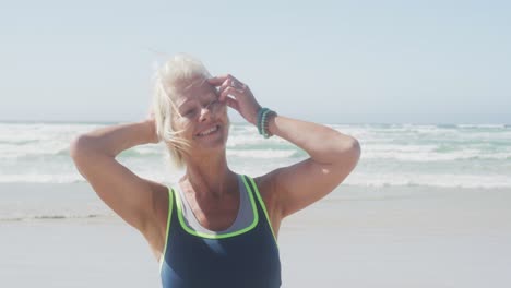Senior-woman-smiling-and-looking-at-camera-on-the-beach