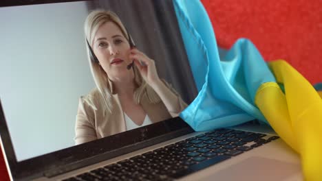 laptop with video conference and presentation near the flag of ukraine.