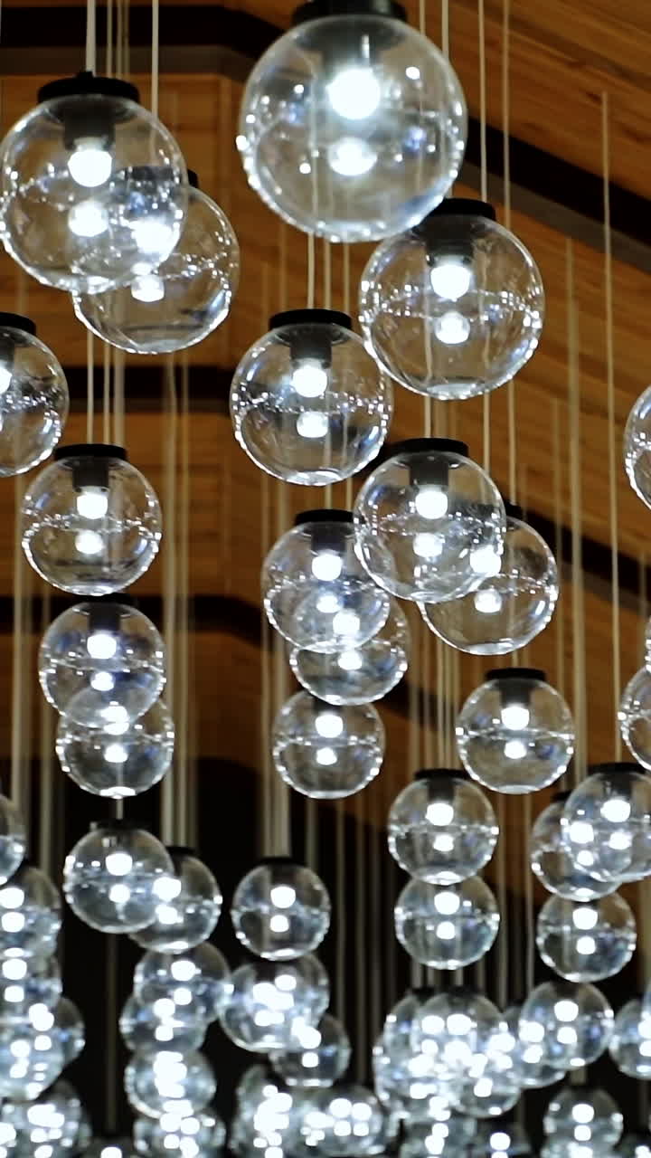 Round transparent bulbs hanging from wooden celling. View from below. Modern interior. Modern light classic lamp hanging from celling. Vintage lamps, bulb lamps. Video from below. Vertical video