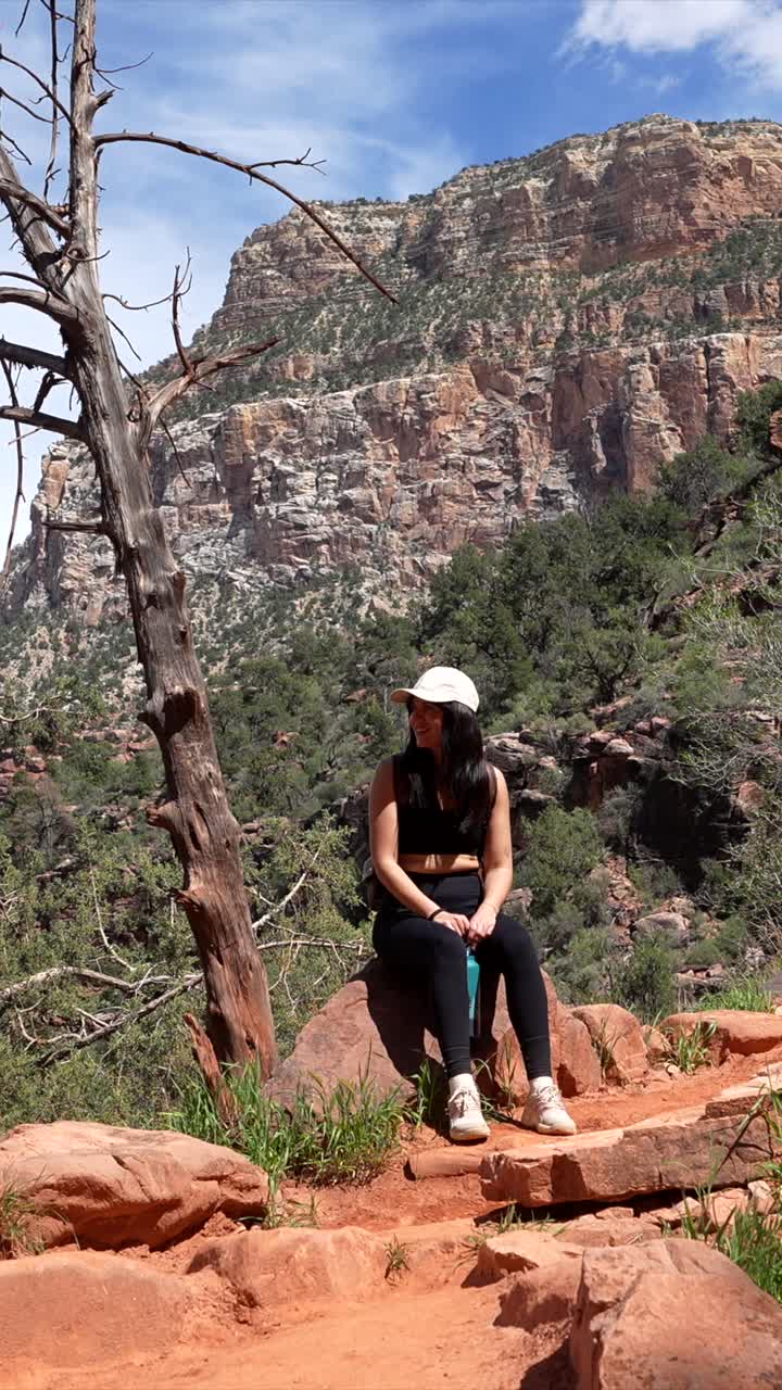 Young Woman Resting on a Hiking Trail in a Mountainous Landscape