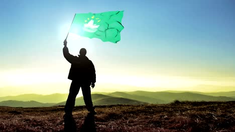 exitoso silueta hombre ganador agitando bandera de macao en la cima de la montaña, fondo de bucle cinemagraph