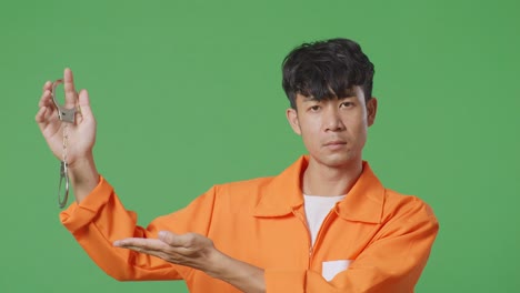 man in an orange jumpsuit holding handcuffs