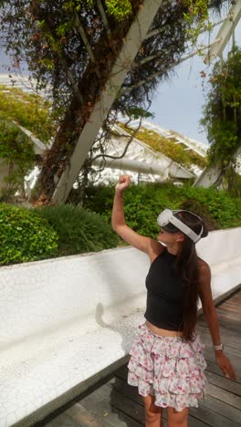 mujer experimentando realidad virtual en un parque moderno