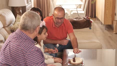 Non-normative family eating a birthday cake in the living room