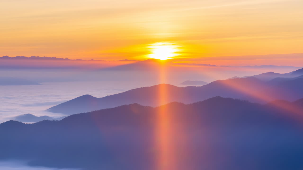 山々の頂上にかかる劇的な日の出、光線と雲海のタイムラプス。
