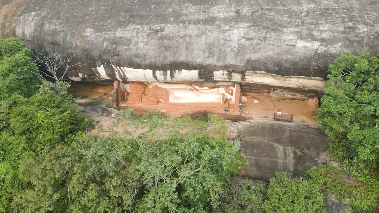 Scatto mozzafiato della statua del Buddha di Sigiriya Pidurangala sotto un'enorme roccia nella natura, Sri Lanka.
