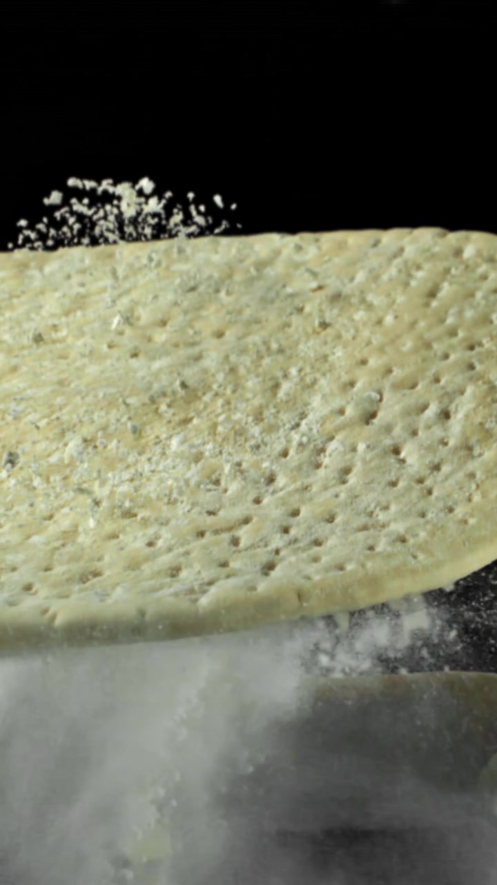 Impasto per pizza che cade con la farina al rallentatore