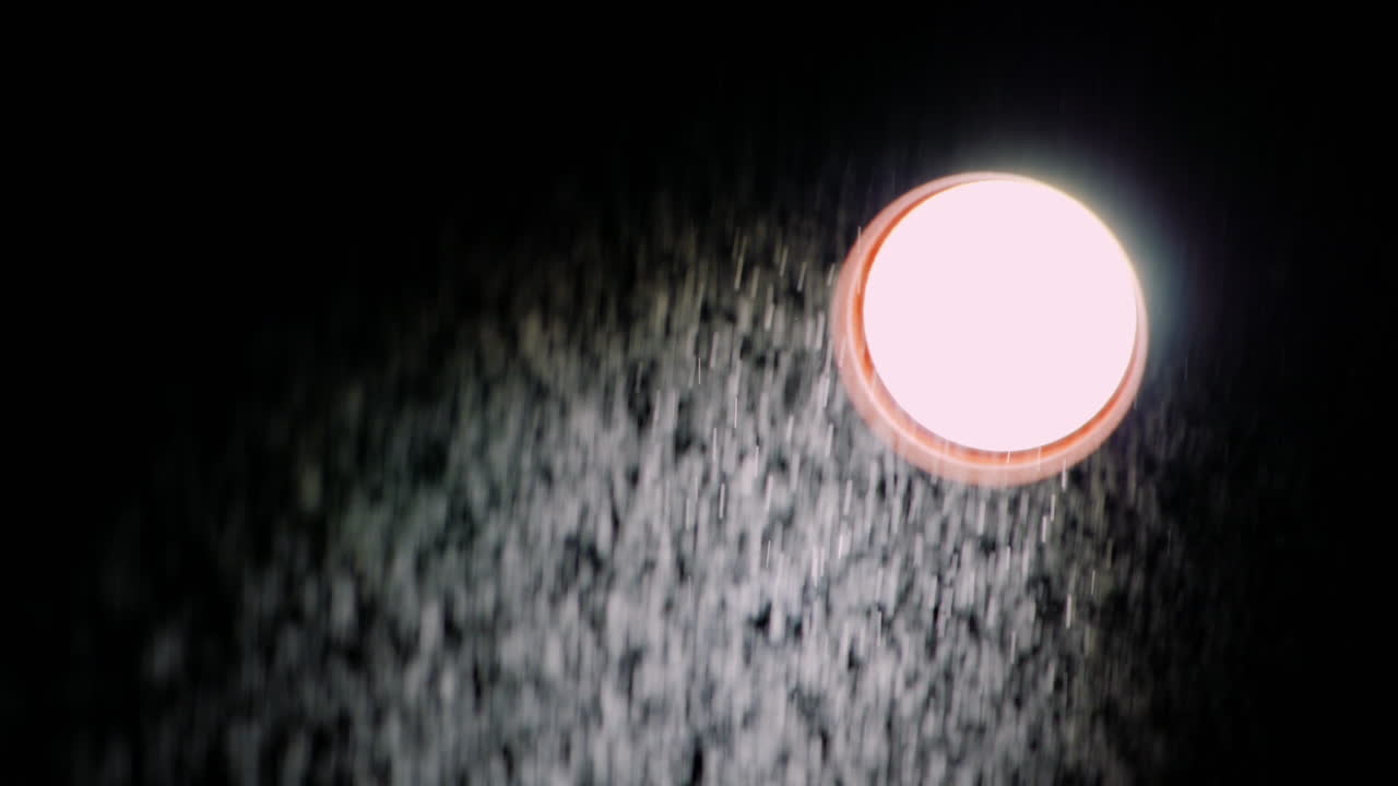 검정색 배경 슬로우 모션 비디오에서 그의 앞에 있는 방향성 광선과 얇은 비