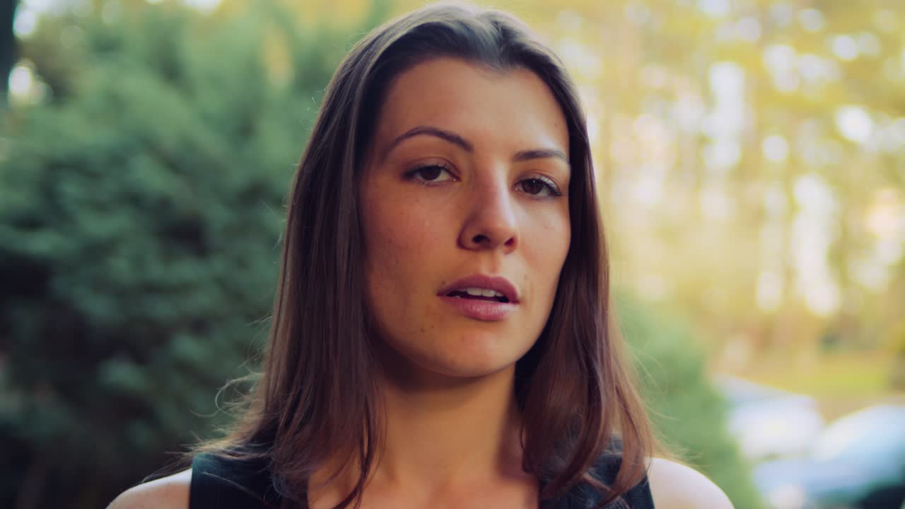 una mujer joven sonríe y respira profundamente en una camiseta negra toma tiempo para reflexionar sobre su riguroso entrenamiento cardiovascular para mantenerse a sí misma y a su corazón en buena forma y en plena condición física