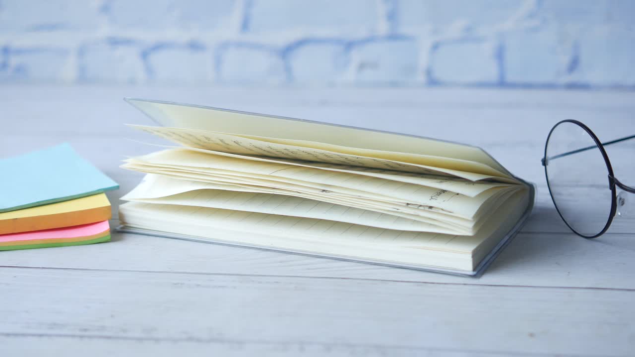 libro de notas abierto con gafas y notas adhesivas