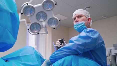 doctor and nurse perform complex operation. portrait of a surgeon in mask during operation. laparoscopic surgery in clinic. medicine concept.