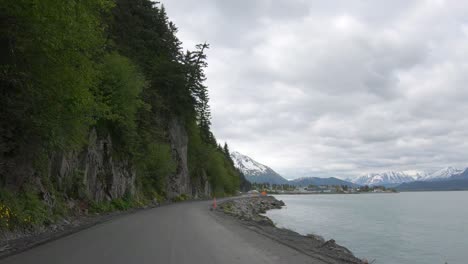 punto de vista: conducir por la carretera de lowell point, que es una carretera de ripio que recorre la ladera de una montaña cubierta de árboles y desciende hasta la bahía del océano