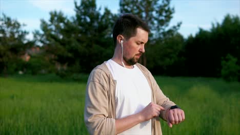 hombre comprobando el reloj inteligente en un parque