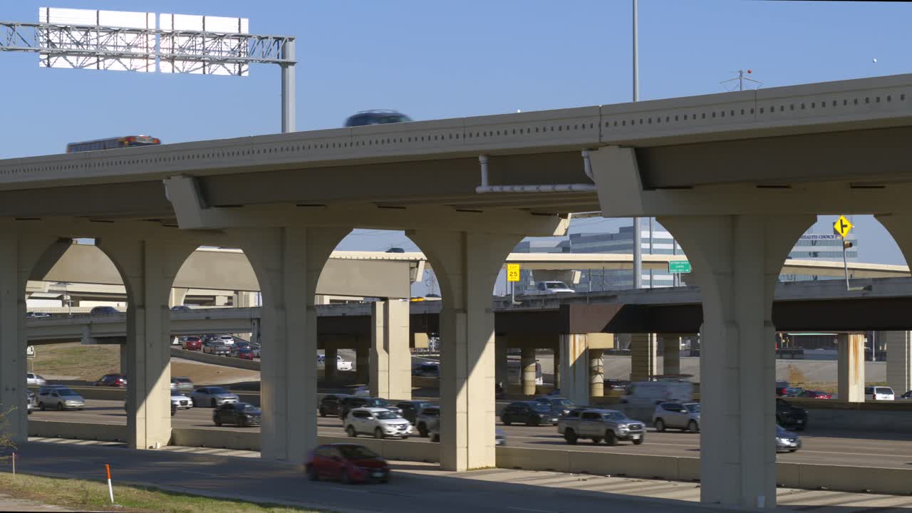 Dynamisches Luftbildmaterial per Drohne, das über einer belebten Autobahn in Houston während der Hauptverkehrszeit herabsteigt und starken Verkehrsfluss sowie städtische Staus einfängt. Ideal für Nachrichtenberichte, Transportthemen, Dokumentationen