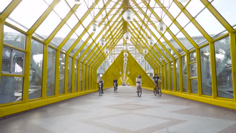 people cycling on a yellow bridge