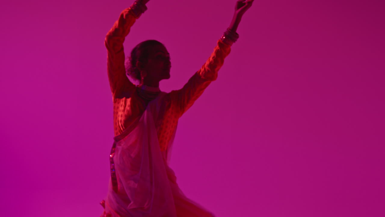 Spinning Female Kathak Dancer Performing Dance Wearing Traditional Indian Dress Against Purple Background 3