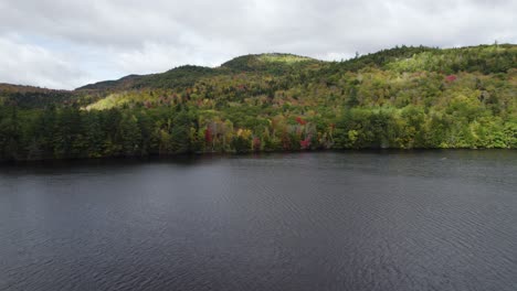 drone flight over androscoggin river towards trees in autumn, new hampshire