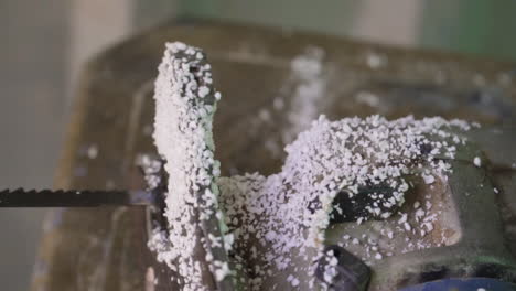 Close-up-sliding-view-of-machine-covered-with-foam-dust-after-making-new-surfboard