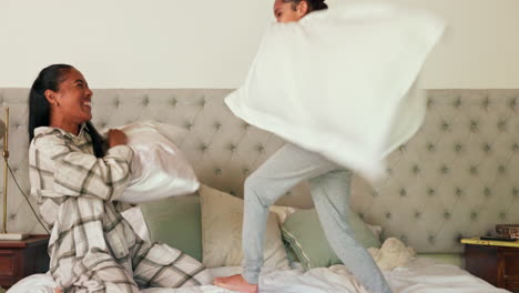 Pillow-fight,-mother-and-daughter-on-bed