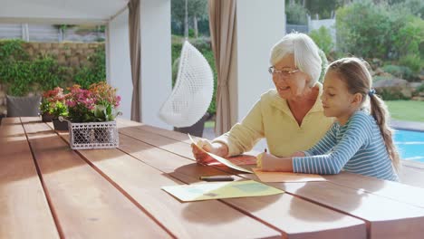 Happy-grandmother-and-little-girl-drawing-together-4K-4k