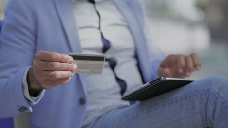 cropped shot of man with credit card using tablet pc