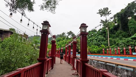 walking along a vibrant red bridge