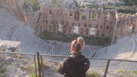 mujer mirando hacia el antiguo anfiteatro griego