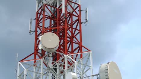 large telecommunication tower against sky and clouds in background