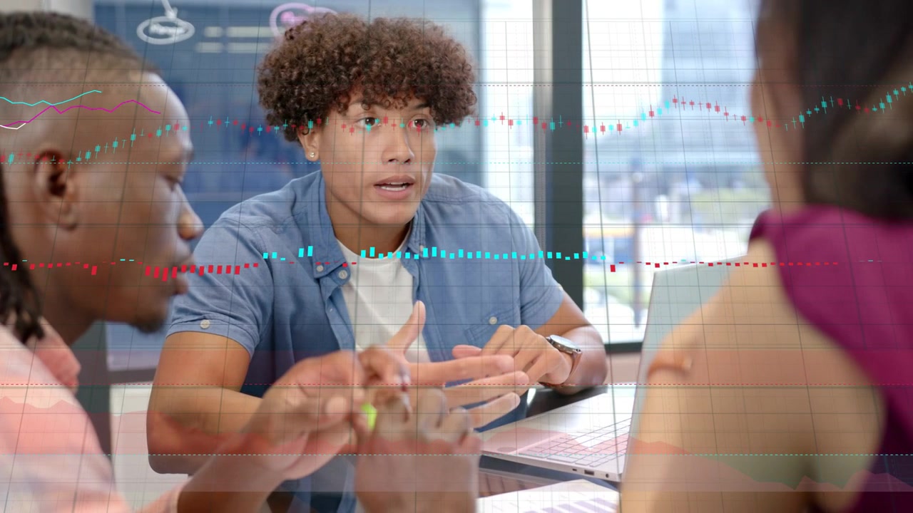 Manden i centrum leder et finansmøde, taster på en bærbar computer, hvilket får animerede diagrammer til at stige op omkring papirer.