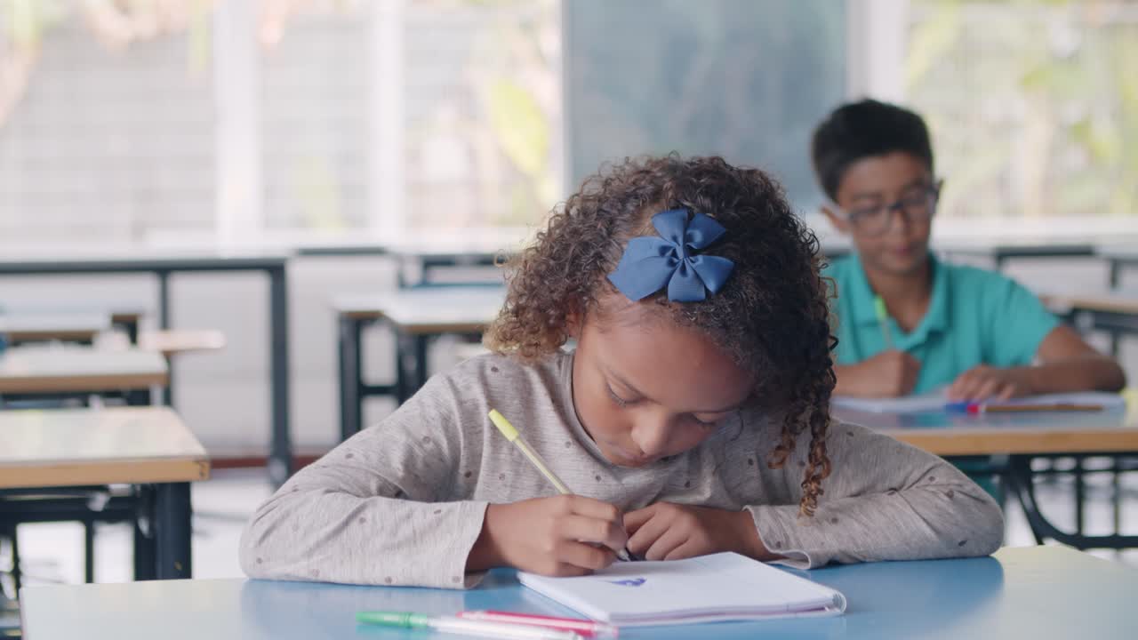 Focused Black primary school student girl using pen