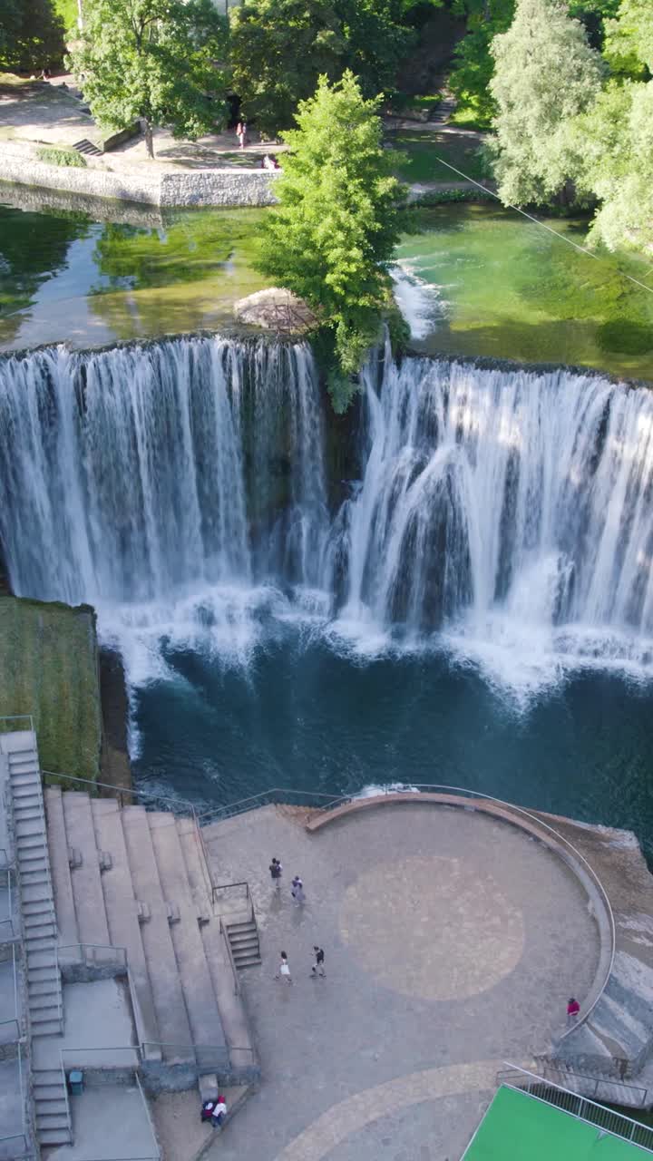 Pliva Waterfall plunging into Vrbas River in Jajce, an amazing natural landmark of Bosnia and Herzegovina. Aerial, Vertical Video
