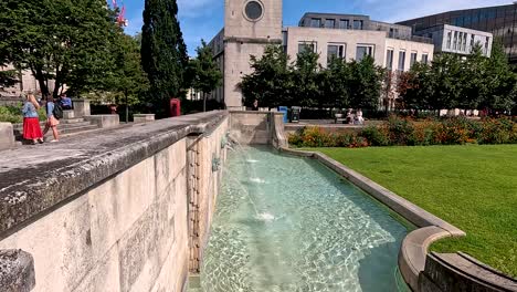 people enjoying a sunny day by the fountain