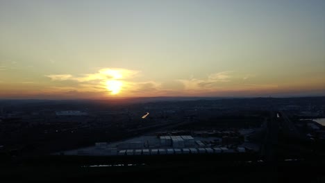 footage-of-sunset-overlooking-yachts-moored-with-traffic-on-a-road-and-shipping-containers-to-be-transported-to-ships-by-trucks